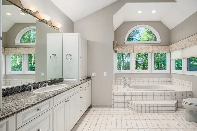 a bathroom with a granite countertop sink a large mirror and a window