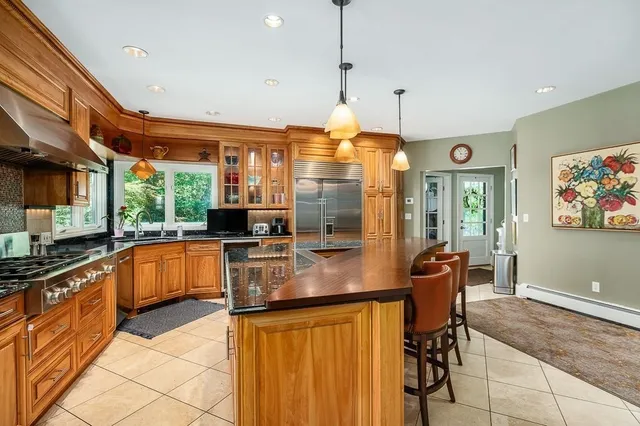 a kitchen with stainless steel appliances granite countertop a sink a stove and a refrigerator