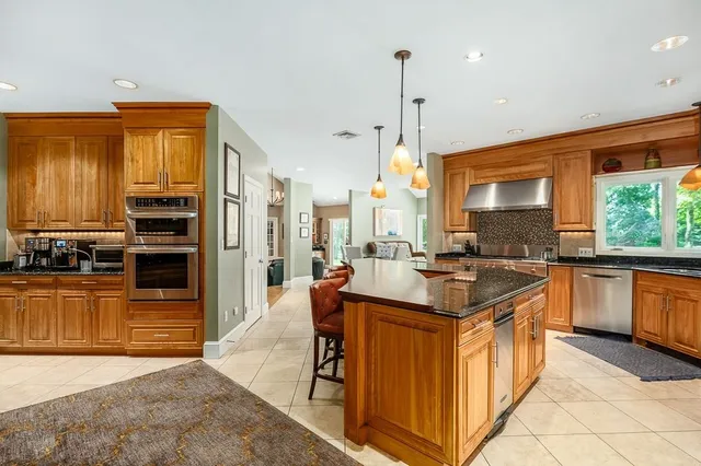 a kitchen with stainless steel appliances granite countertop a stove a sink and a refrigerator