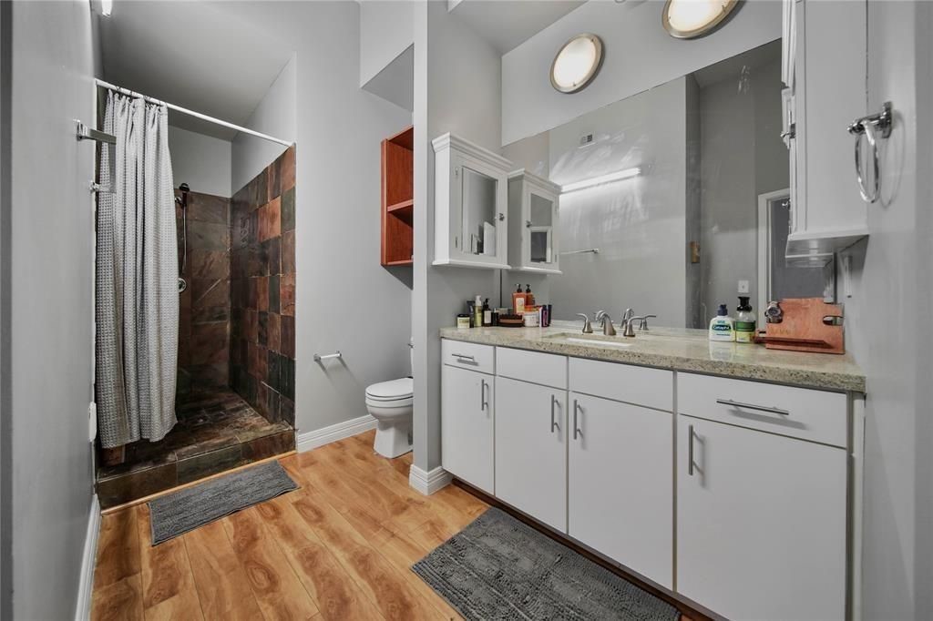 705 Main Street, Unit 610 Houston, TX 77002 - Photo 12 of 15 a spacious bathroom with a granite countertop sink a toilet and a shower