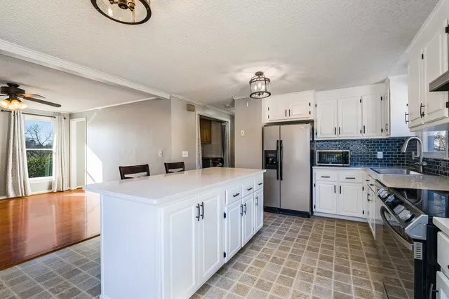 a view of an empty room with wooden floor and window