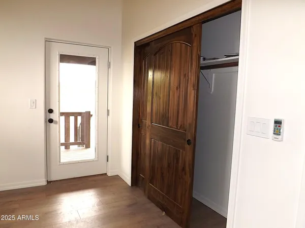 a view of an empty room with wooden floor and windows