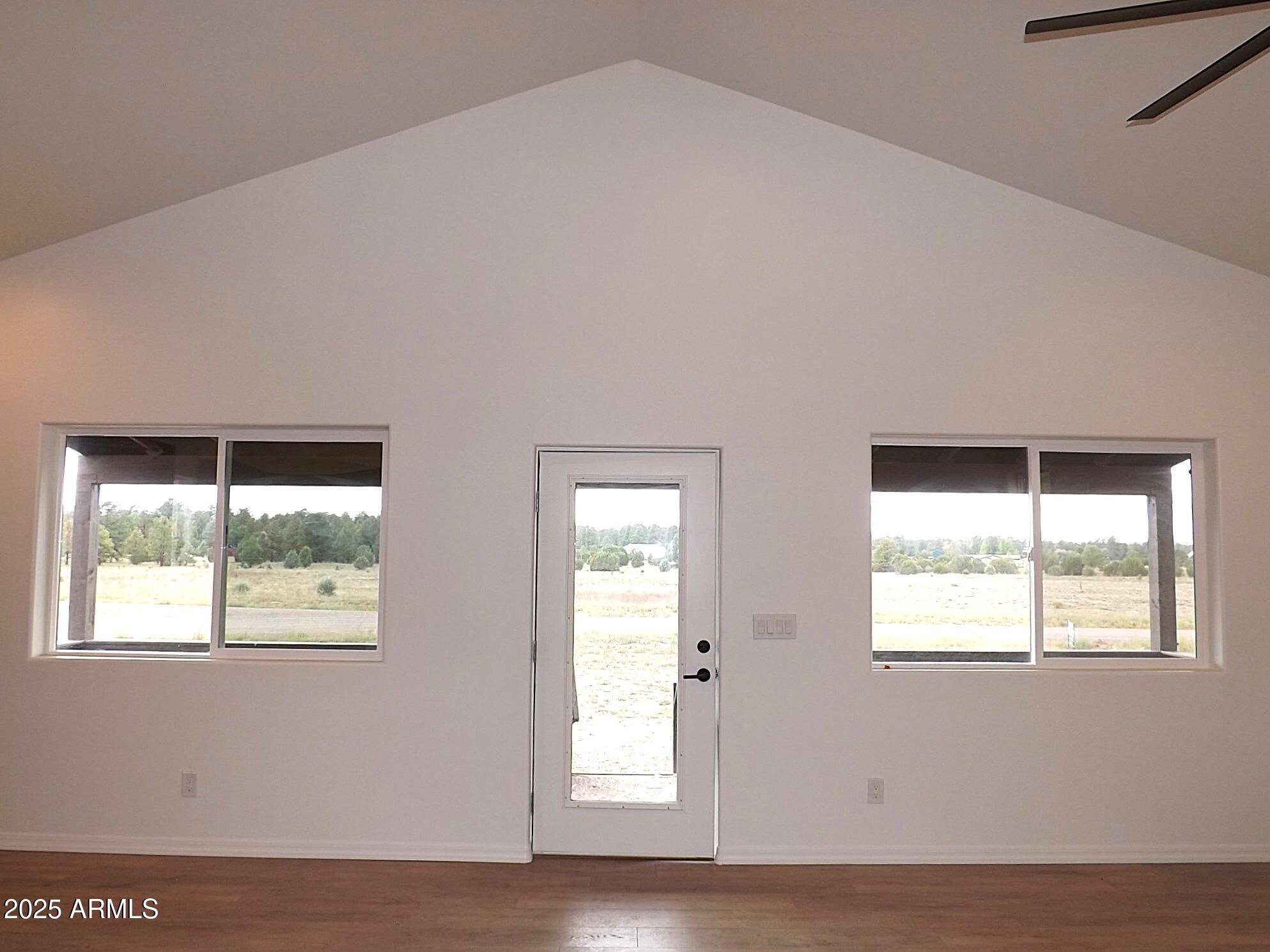 2763 Sunflower Drive Overgaard, AZ 85933 - Photo 16 of 18 a view of an empty room with wooden floor and windows