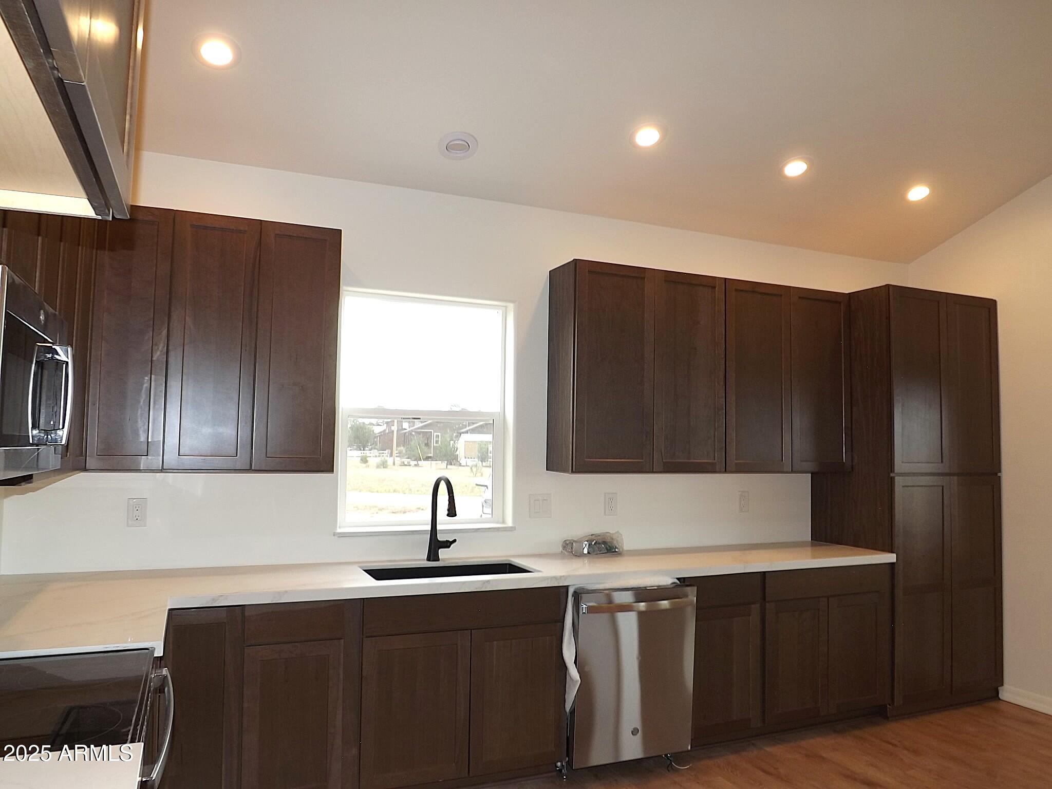 2763 Sunflower Drive Overgaard, AZ 85933 - Photo 17 of 18 a kitchen with stainless steel appliances granite countertop a sink a stove a refrigerator and cabinets