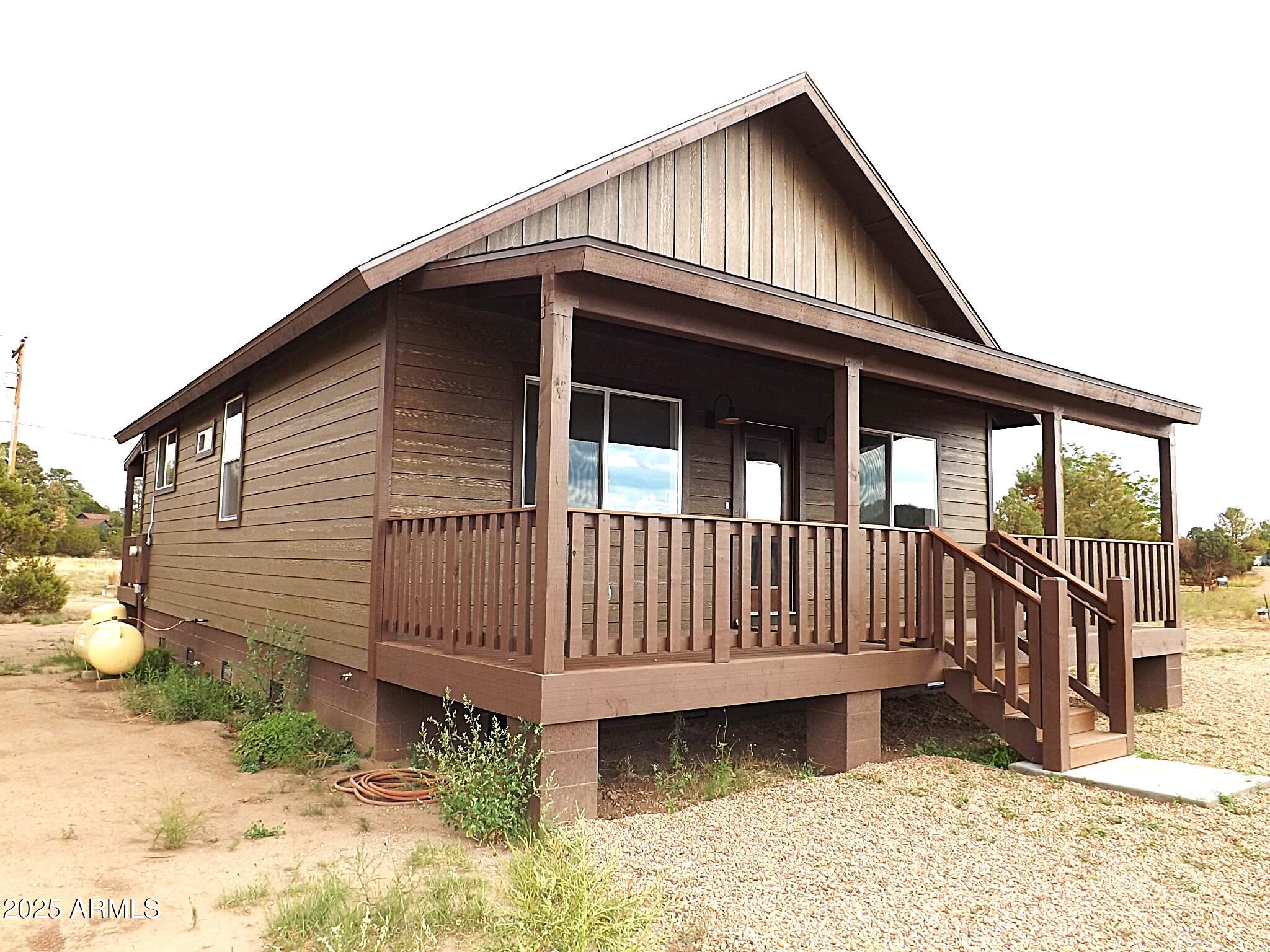 2763 Sunflower Drive Overgaard, AZ 85933 - Photo 3 of 18 a view of wooden house with a small yard and wooden fence