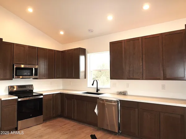 a view of a room with a ceiling fan and hardwood floor