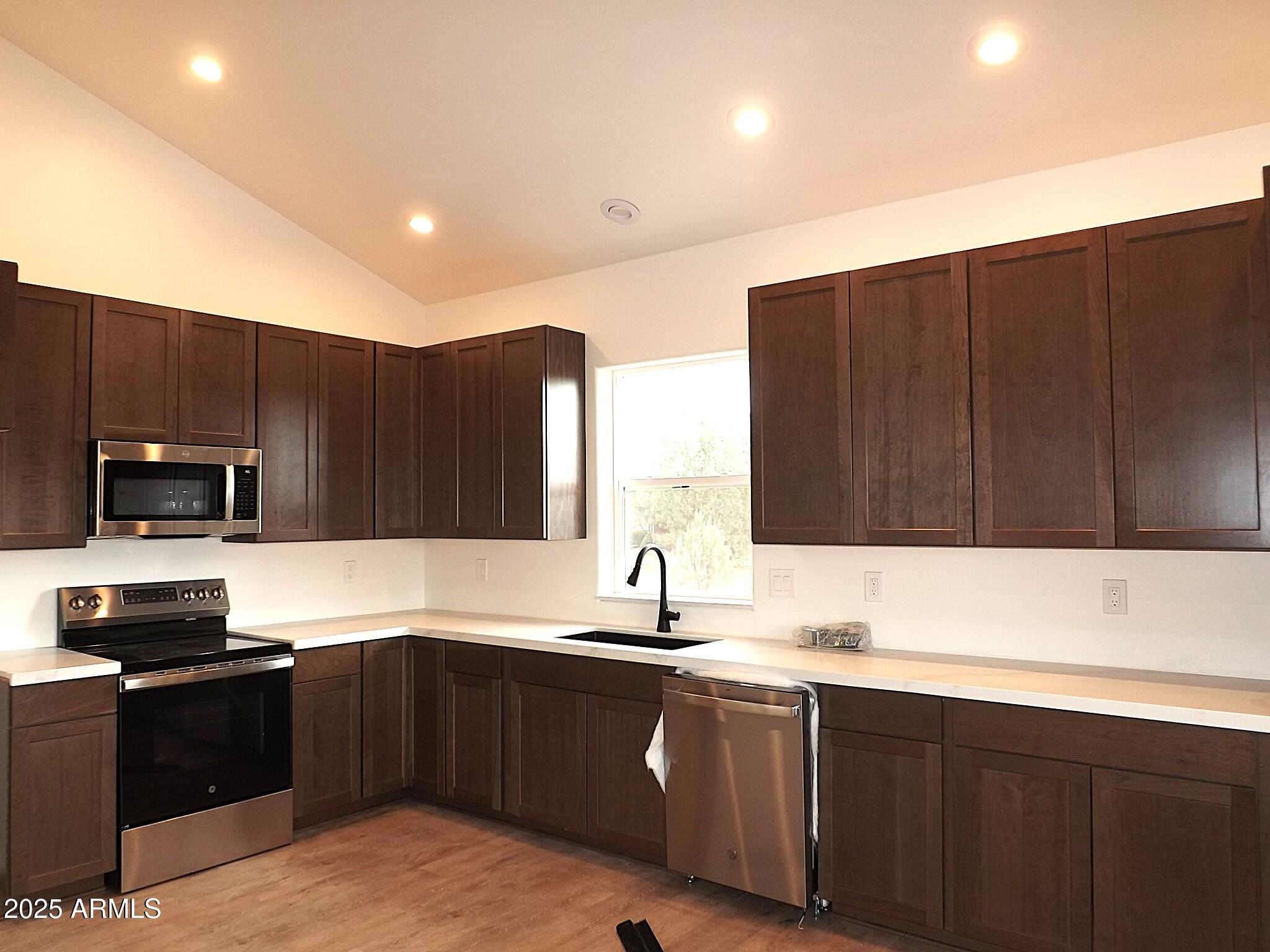 2763 Sunflower Drive Overgaard, AZ 85933 - Photo 6 of 18 a kitchen with kitchen island granite countertop a sink dishwasher stove and cabinets with wooden floor