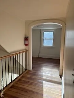 a view of a hallway with wooden floor and staircase