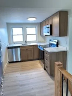 a large kitchen with a sink and dishwasher a stove top oven with wooden floor