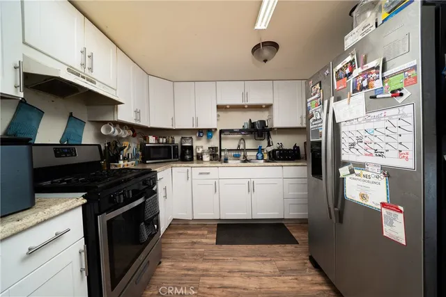 a kitchen with stainless steel appliances granite countertop a refrigerator and a stove