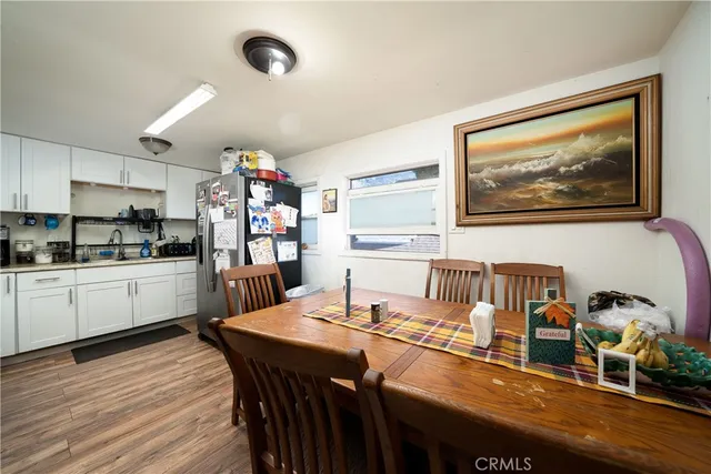 a kitchen with granite countertop a dining table chairs stainless steel appliances and cabinets