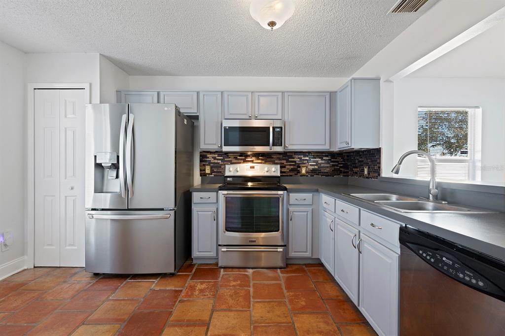 1533 Sunset View Circle Apopka, FL 32703 - Photo 11 of 23 a kitchen with granite countertop a refrigerator and a sink