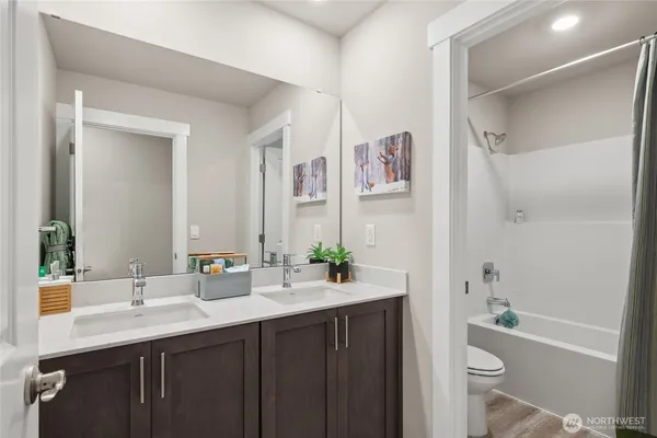 a bathroom with a tub sink toilet and a mirror