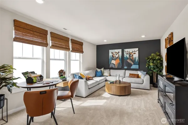 a living room with furniture a flat screen tv and a floor to ceiling window