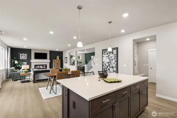 a living room with furniture kitchen view and a large window