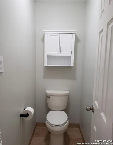 a bathroom with a toilet and a mirror