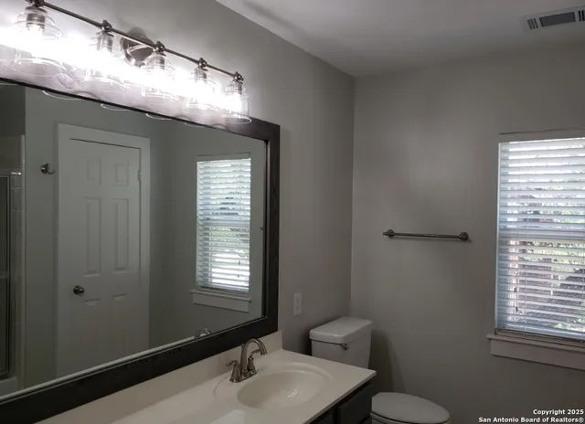 a bathroom with a sink toilet and mirror