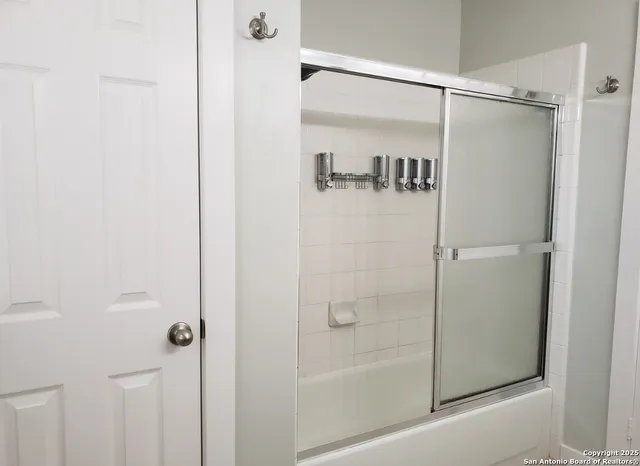 a bathroom with a glass shower door