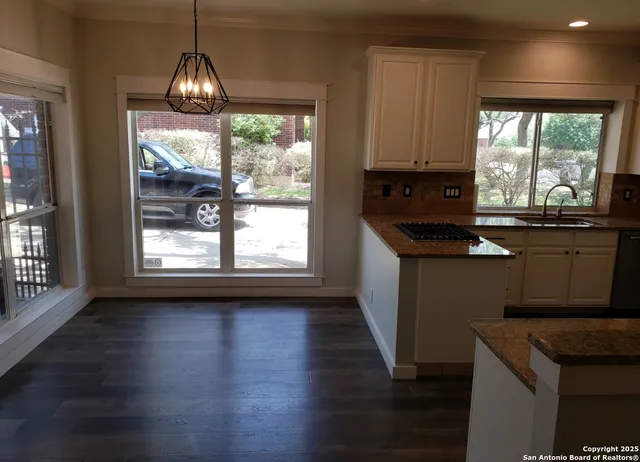 a kitchen with granite countertop a sink cabinets and stainless steel appliances