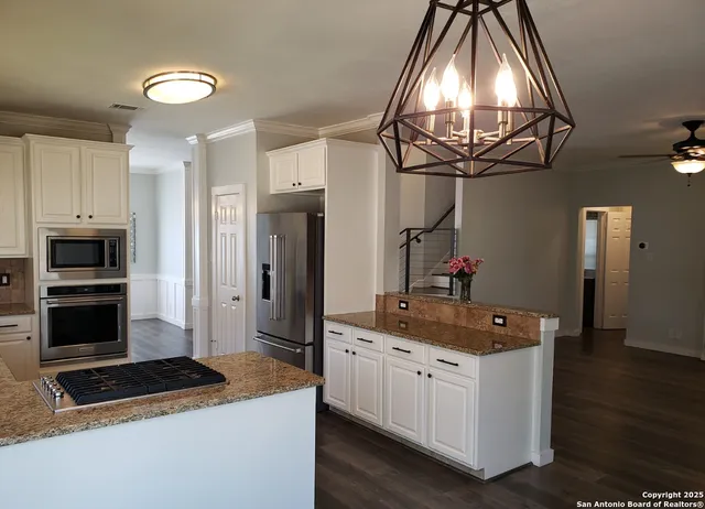 a kitchen with stainless steel appliances granite countertop a refrigerator a stove and a sink