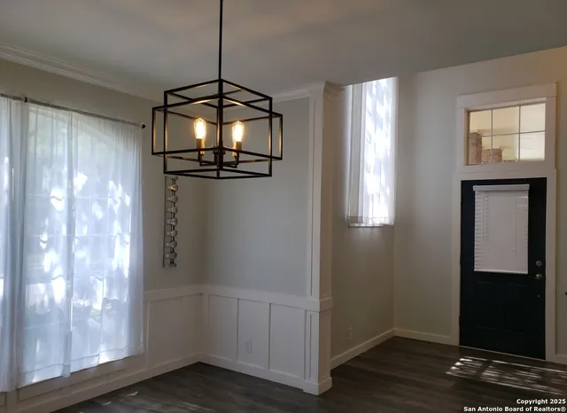 a view of a room with wooden floor mirror and windows
