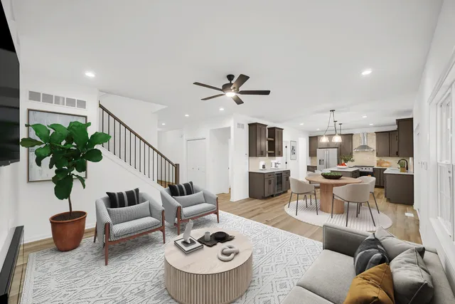 a living room with furniture kitchen view and a potted plant