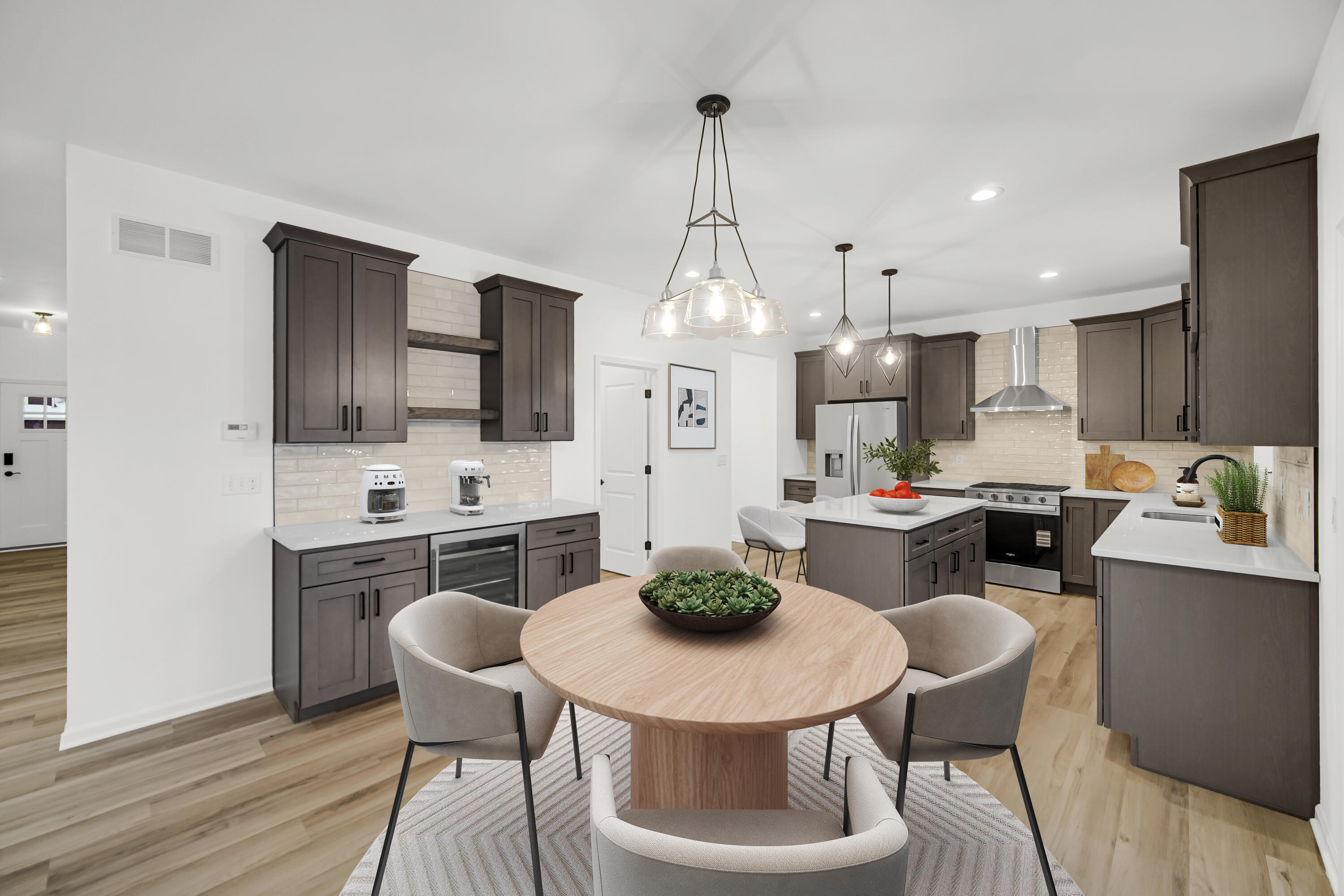 716 Verdano Terrace Crown Point, IN 46307 - Photo 4 of 26 a kitchen with stainless steel appliances kitchen island granite countertop a dining table chairs and white cabinets
