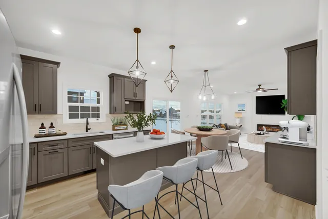 a view of a dining room and livingroom with furniture wooden floor a chandelier