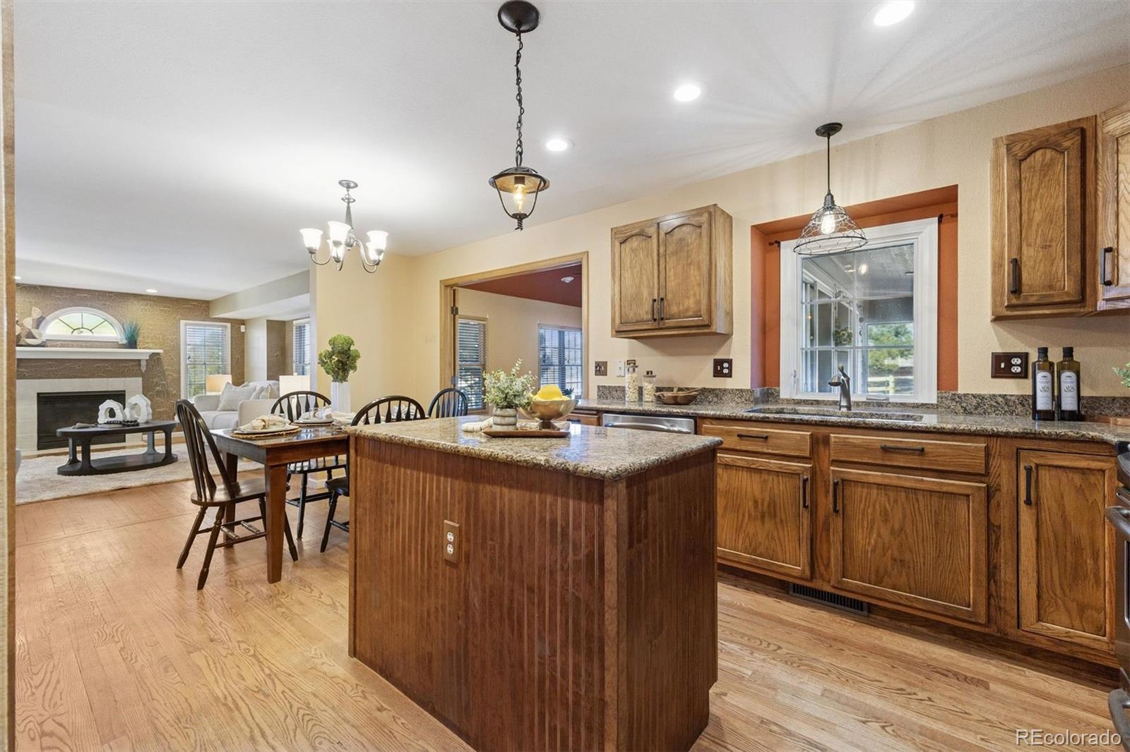 3779 Pasture Gate Circle Elizabeth, CO 80107 - Photo 27 of 49 a large kitchen with lots of counter space dining table and stainless steel appliances