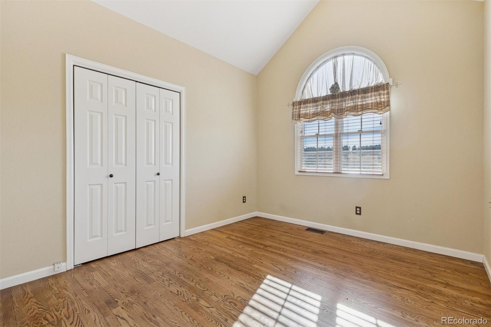 3779 Pasture Gate Circle Elizabeth, CO 80107 - Photo 39 of 49 an empty room with wooden floor chandelier and windows