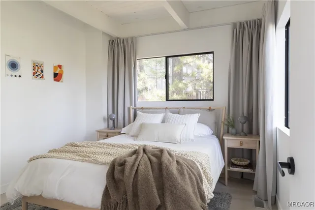 a bed sitting in a bedroom next to a window