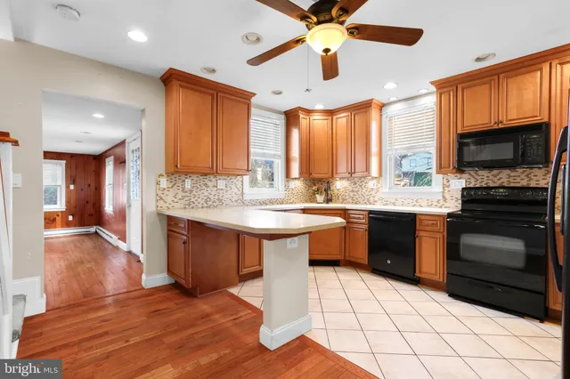a large kitchen with a large counter top space appliances and cabinets