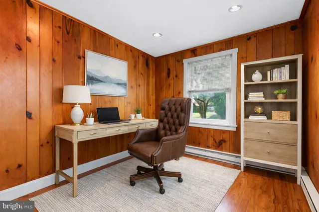 a view of a workspace with furniture and a window