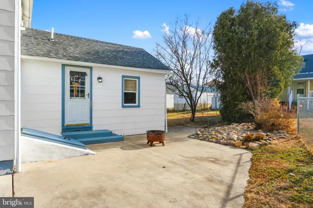 a backyard of a house with barbeque oven fire pit table and chairs