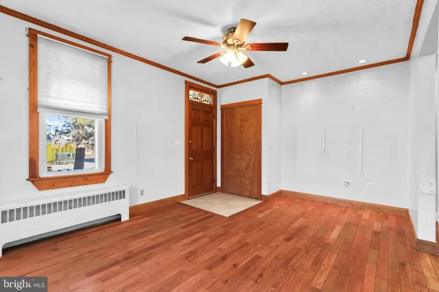 a view of an empty room with a window and a ceiling fan