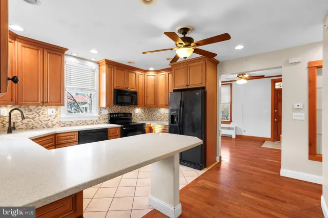 a kitchen with stainless steel appliances a sink cabinets and wooden floor