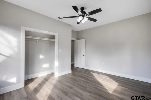 a view of an empty room with wooden floor