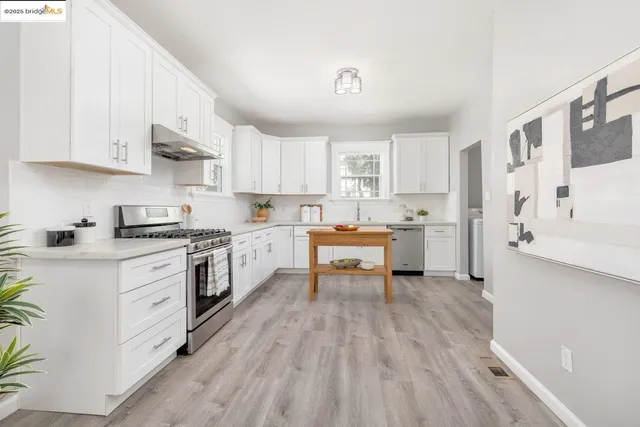 a kitchen with white cabinets and white appliances