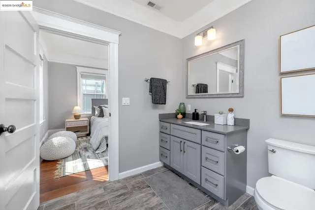 a bathroom with a granite countertop toilet sink and mirror