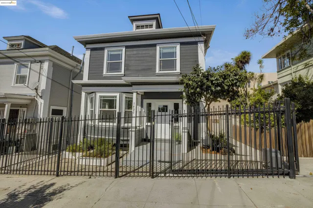 a front view of a house with a iron gate