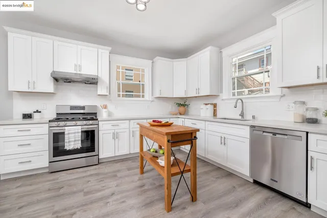 a kitchen with stainless steel appliances stove top oven and cabinets