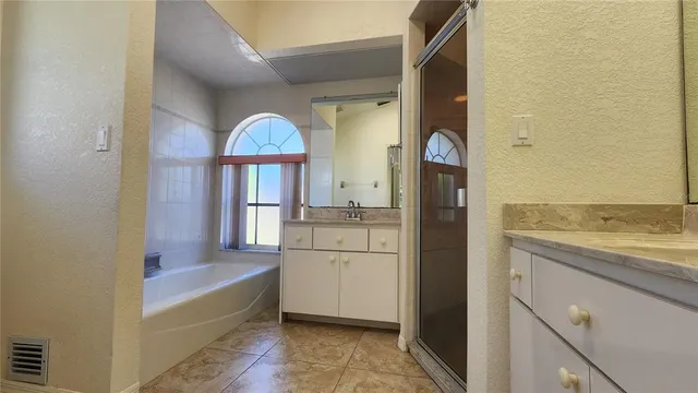 a bathroom with a tub sink and mirror