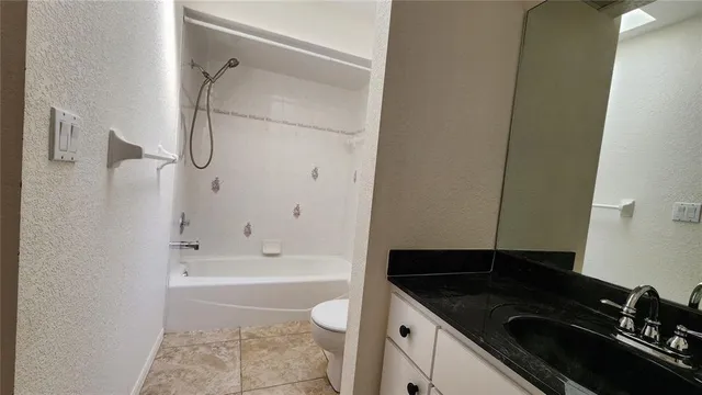 a bathroom with a granite countertop sink a toilet and bathtub