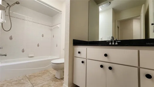 a bathroom with a granite countertop sink a toilet and shower
