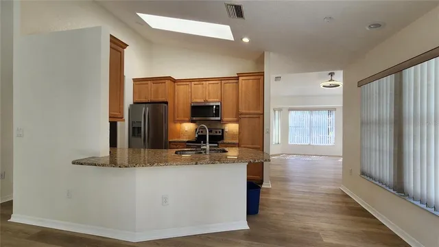 a view of a kitchen with kitchen island a counter top space and stainless steel appliances