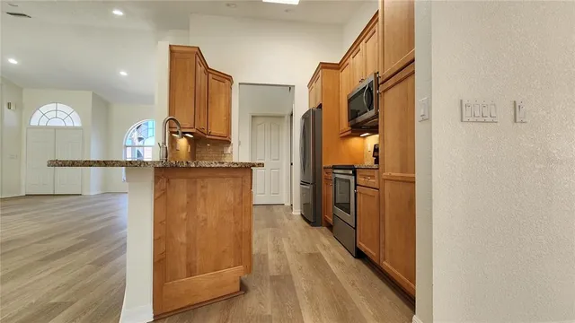 a kitchen with stainless steel appliances granite countertop a refrigerator and a sink