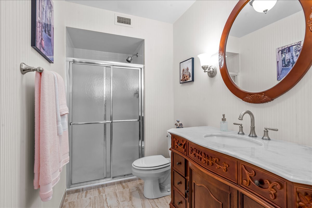 6007 North Sheridan Road, Unit 37B Chicago, IL 60660 - Photo 19 of 31 a bathroom with a toilet a sink and a mirror
