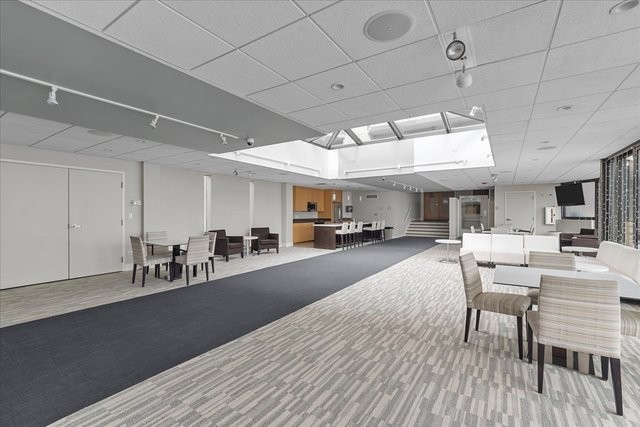 6007 North Sheridan Road, Unit 37B Chicago, IL 60660 - Photo 30 of 31 a dining hall with stainless steel appliances granite countertop a stove a sink dishwasher a dining table and chairs with wooden floor