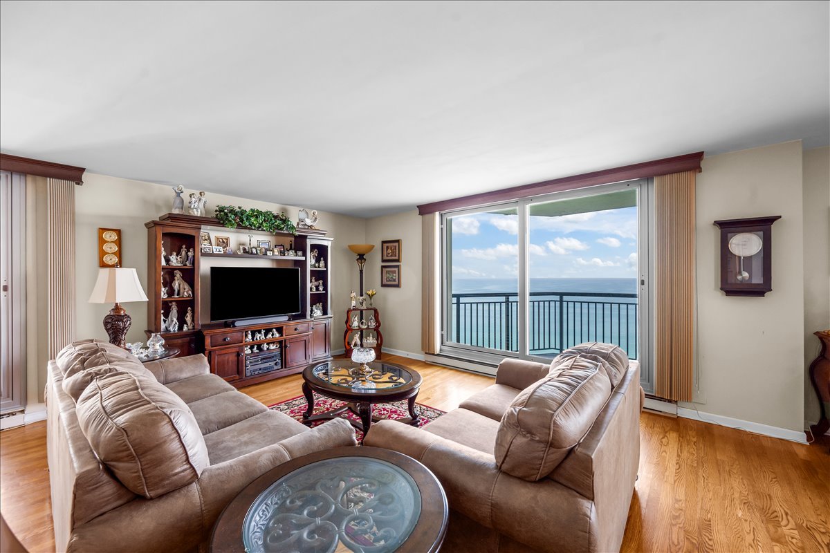6007 North Sheridan Road, Unit 37B Chicago, IL 60660 - Photo 5 of 31 a living room with furniture a flat screen tv and a large window