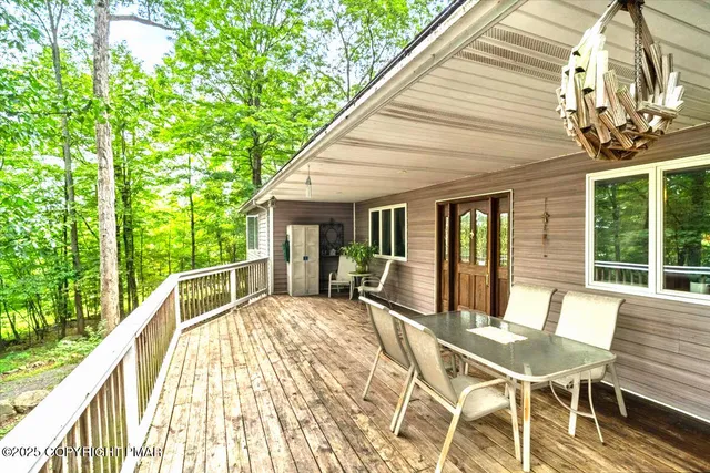 a view of a patio with a table chairs and wooden floor
